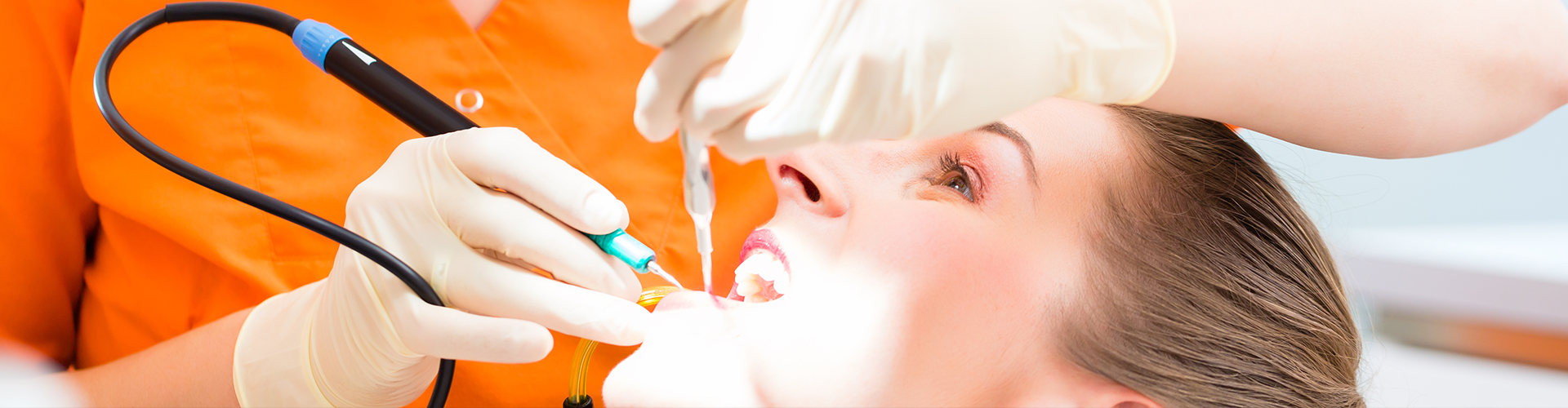dentist using dental tools in a patient's mouth